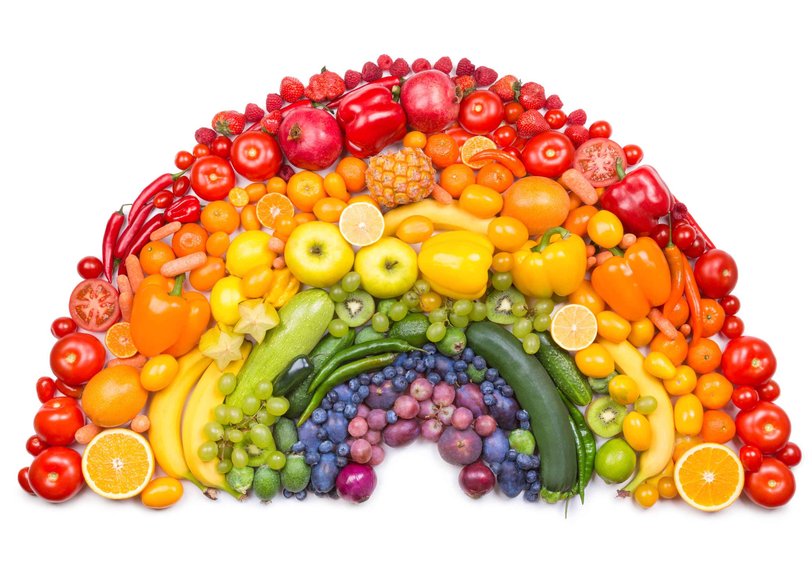 A rainbow made of fruit and vegetables on a white backdrop