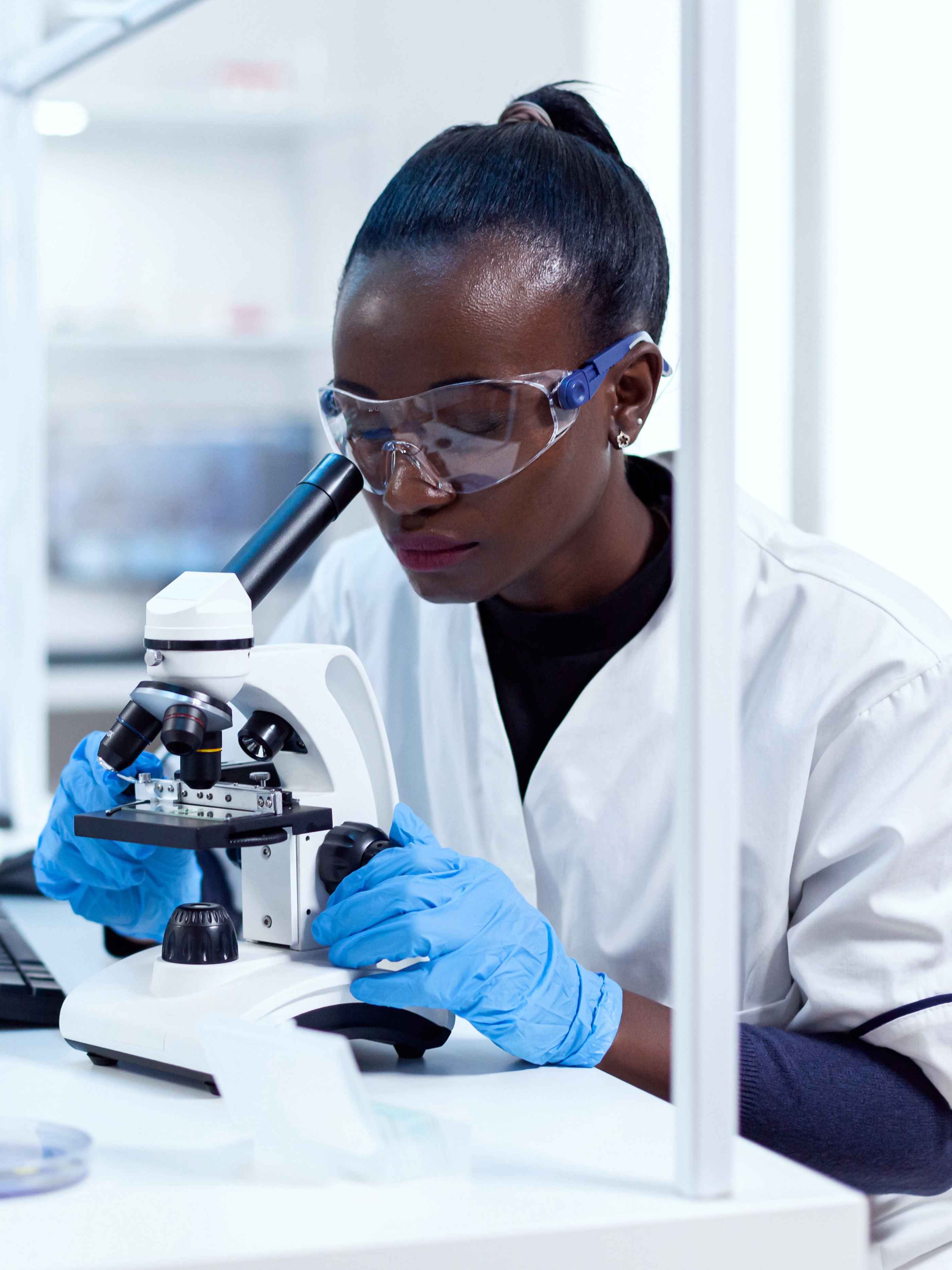 Woman in laboratory looking into microscope